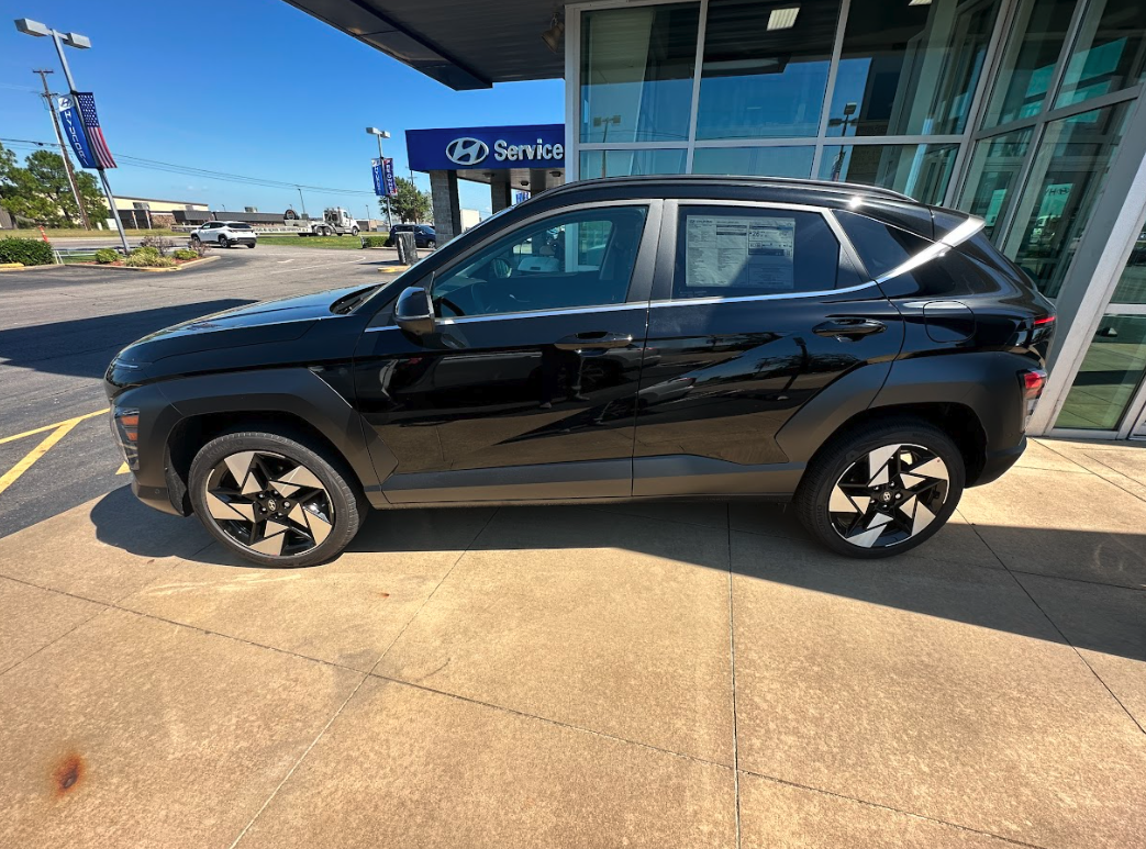 A black Hyundai SUV parked outside Crain Hyundai of Fort Smith, perfect for back-to-school shopping and commuting.